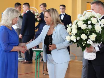 Zdjęcie przedstawia wójt Martę Cytryńską i sekretarza Tomasza Podhoreckiego, wręczających bukiet kwiatów pani dyrektor Alinie Jarosz