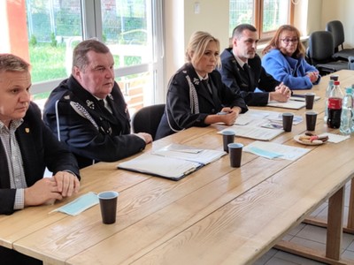 Zdjęcie przedstawia stół prezydialny z zaproszonymi gośćmi na spotkanie