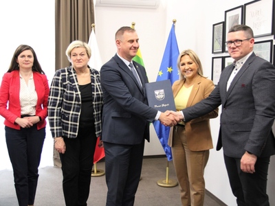 Zdjęcie samorządowców trzymających umowę na realziację inwestycji