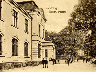 Na pierwszym planie siedziba przedwojennej poczty oraz mieszkańcy Sulęcina.