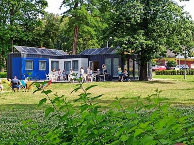 Widok na tzw. Kontener Kultury oraz dzieci biorące udział w zajęciach muzycznych.