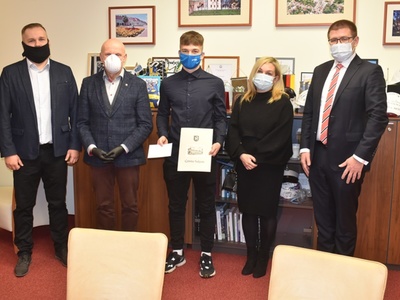 Łukasz Chudziński z pamiątkowym listem gratulacyjnym w dłoni u boku Przewodniczącego Rady Miejskiej w Sulęcinie Zbigniewa Szczepańskiego, Burmistrza Sulęcina Dariusza Ejcharta, swojej mamy oraz trenera.