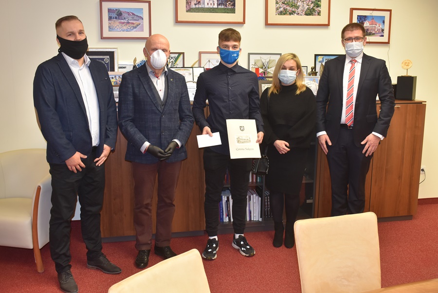 Łukasz Chudziński z pamiątkowym listem gratulacyjnym w dłoni u boku Przewodniczącego Rady Miejskiej w Sulęcinie Zbigniewa Szczepańskiego, Burmistrza Sulęcina Dariusza Ejcharta, swojej mamy oraz trenera.