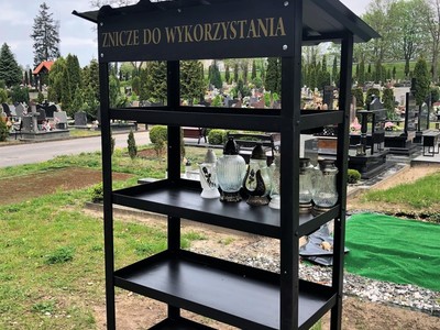 Na zdjęciu znajduje się regał przeznaczony na znicze do ponownego wykorzystania, ustawiony na cmentarzu komunalnym w Sulęcinie.