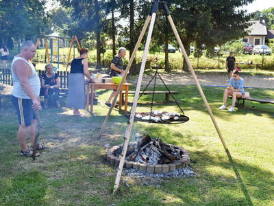 Piknik pod chmurką w Grochowie. Uczestnicy w trakcie grillowania.