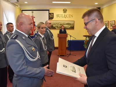 Święto policji w Sulęcinie. Burmistrz Sulęcina podczas wręczania listu gratulacyjnego.
