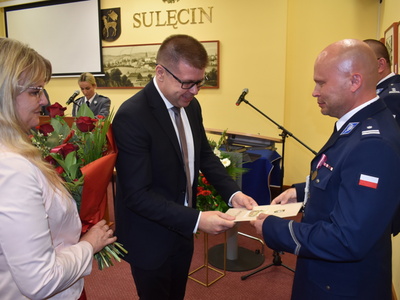 Święto policji w Sulęcinie. Burmistrz Sulęcina wraz z Zastępcą wręczający list gratulacyjny.