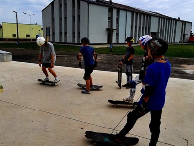 Alt= „Zdjęcie przedstawia uczestników warsztatów deskorolkowych na skateparku w Ciasnej."
