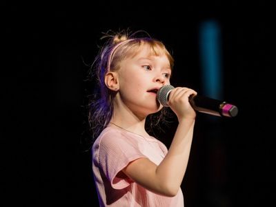 Alt="Zdjęcie przedstawia Maję podczas wystepu. Zdjęcia pochodzą ze strony: https://mdk.lubliniec.pl/muzyczno-taneczny-zawrot-glowy-czyli-xxii-lubliniecka-wiosna-kulturalna-w-mdk/ , autor Daniel Dmitriew."