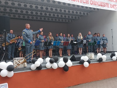 Alt="Zdjęcie przedstawia występ Gminnej Orkiestry Dętej z Ciasnej wraz z Zespołem Tańca Mażoretkowego "Copacabana" podczas XIII Ogólnopolskiego Przeglądu Paradnych Orkiestr Dętych w Rowach."