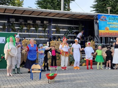 Alt="Zdjęcie przedstawia występ przedszkolaków wraz z seniorami z Dziennego Domu Seniora + z Panoszowa."
