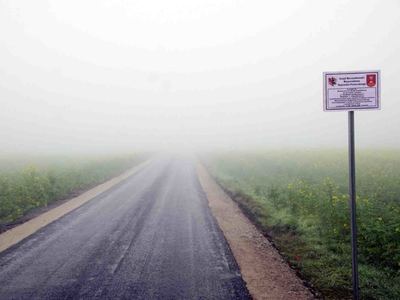 Zdjęcie na którym widać drogę asfaltową prowadzącą w kierunku pól uprawnych [400x300]