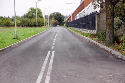 Zdjęcia przedstawiają drogę między domami oraz terenami zielonymi.