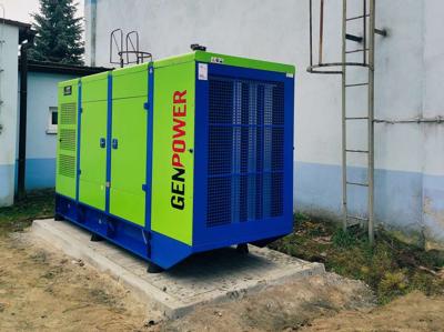 Agregat prądotwórczy - mobilny, w tle ściana budynku stacji uzdatniania wody