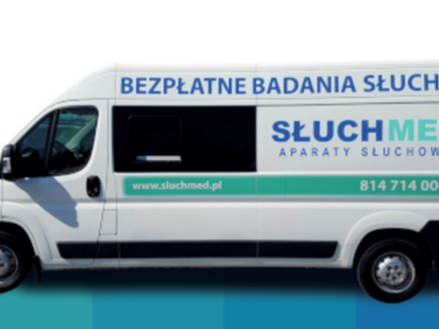 Biały samochód z napisami promującymi bezpłatne badanie słuchu