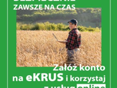 Plakat reklamujący zakładanie konta eKRUS. Zielone tło z białymi napisami: Szybko, bezpiecznie, zawsze na czas; Załóż konto na eKRUS i korzystaj z usług online. Na środku plakatu zdjęcie: w dojrzałej pszenicy stoi uśmiechnięta, młoda kobieta z otwartym laptopem na lewej dłoni. Ubrana w czarną czapeczkkę z daszkiem, kraciastą koszulę i siwe spodnie.