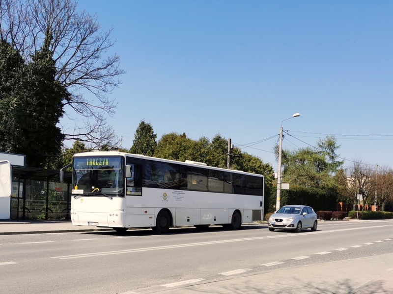 Zdjęcie przedstawia autobus stojący na przystanku