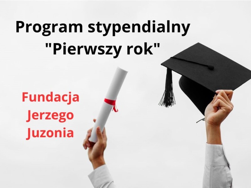 Baner przedstawia dwie ręce trzymające zwinięty w rulon papier oraz czapkę akademicką