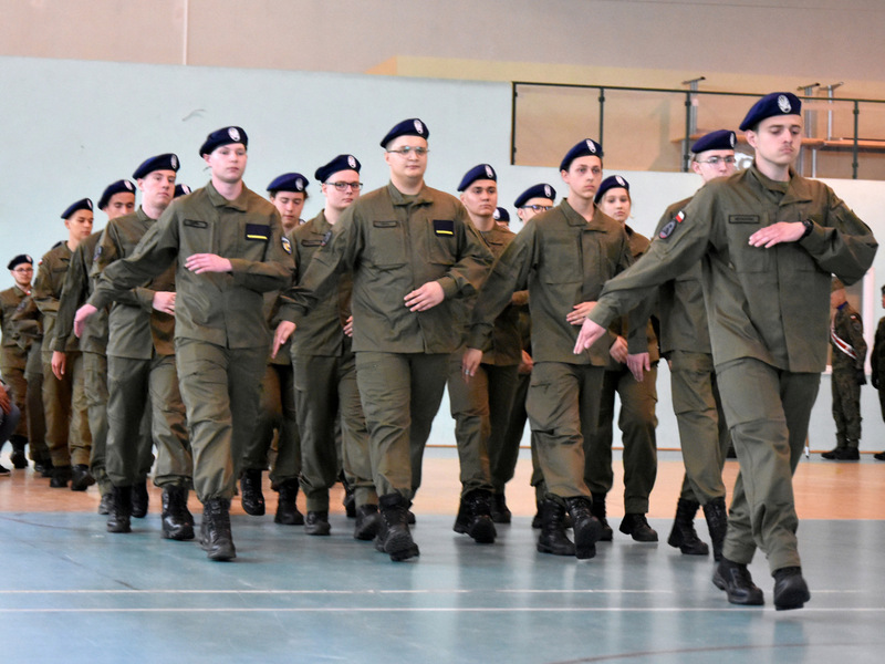 Zdjęcie przedstawia maszerujących uczniów