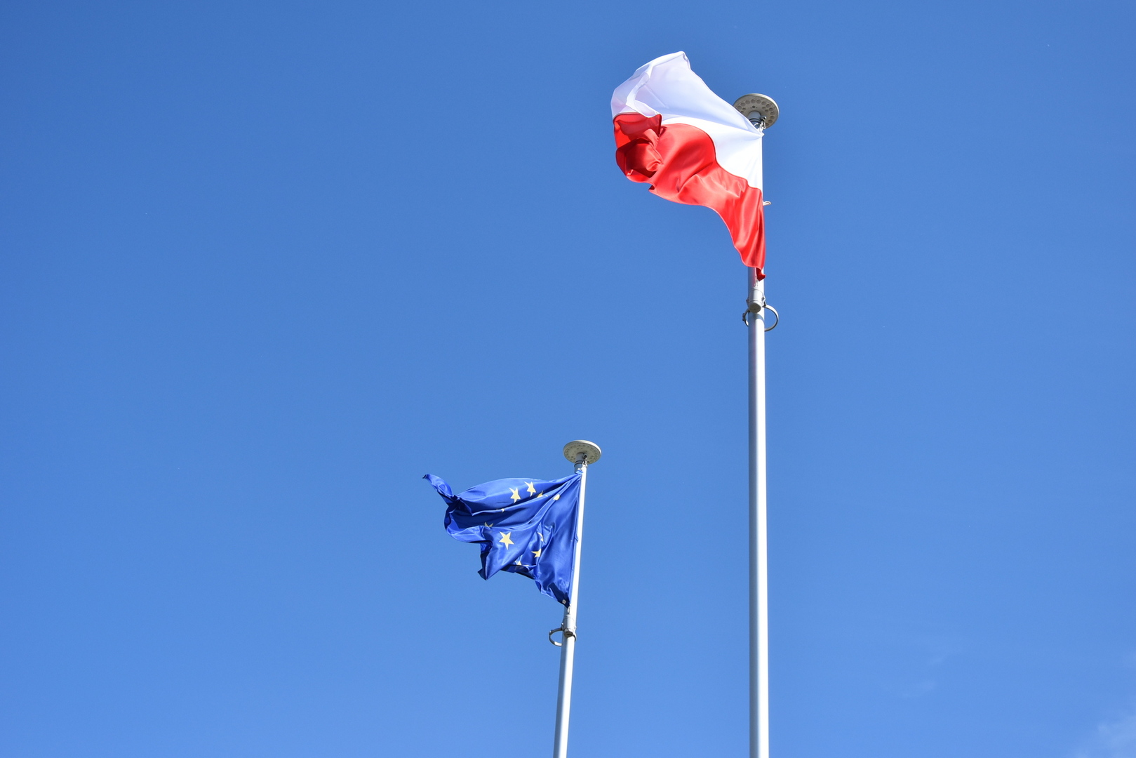 Zdjęcie przedstawia flagę UE i flagę biało-czerwoną