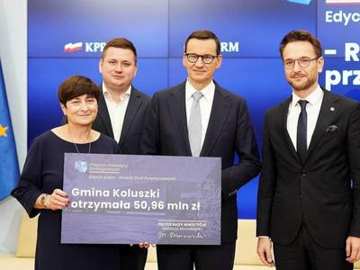 Zdjęcie przedstawia Zastępcę Burmistrza, Dyrektora Wydziału Inwestycji, Premiera oraz Ministra Rozwoju i Technologi trzymających bon na rozwój strefy.
