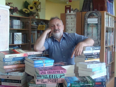 Dyrektor Biblioteki pozuje z książkami