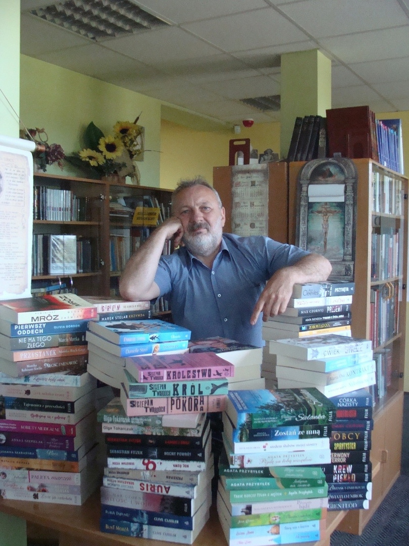 Dyrektor Biblioteki pozuje z książkami