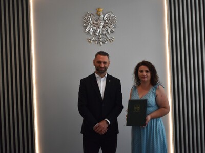 nauczyciel z wręczonym awansem na zdjęciu z wójtem gminy 