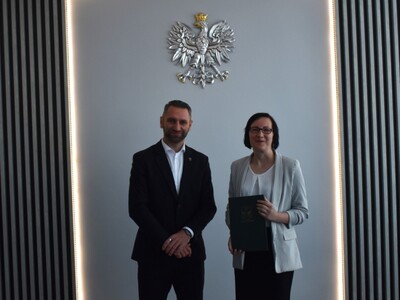 nauczyciel z wręczonym awansem na zdjęciu z wójtem gminy 