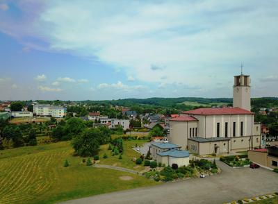 Zdjęcie przedstawia widok kościoła i panoramę Syryni.