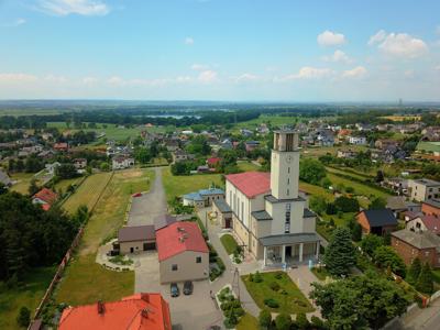 Zdjęcie przedstawia widok kościoła i panoramę Syryni.