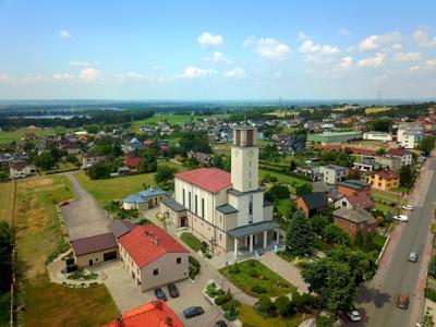 Zdjęcie przedstawia widok kościoła i panoramę Syryni.