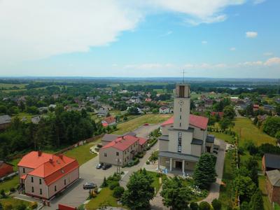 Zdjęcie przedstawia widok kościoła i panoramę Syryni.