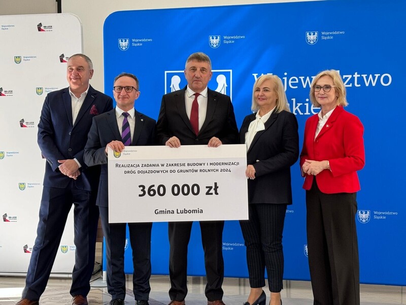 Zdjęcie przedstawia przekazanie czeku na 360 000 zł na modernizację drogi. Na zdjęciu Wójt Gminy Lubomia oraz przedstawiciele urzędu marszałkowskiego i rady sejmiku