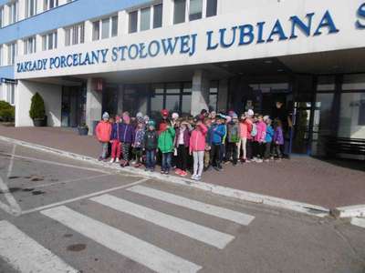 Dzieci stoją przed budynkiem porcelany 