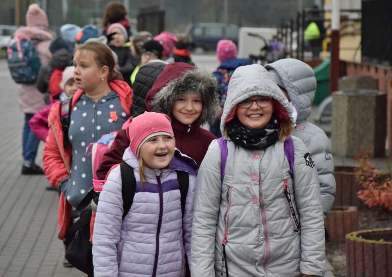 Dzieci pozują do zdjęcia na chodniku 