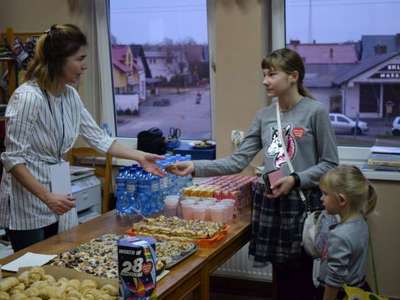 Zdjęcie przedstawia dziewczynkę kupującą produkty podczas finału WOŚP 