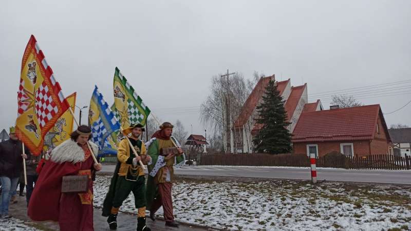 Zdjęcie przedstawia przebranych mężczyzn idących drogą 