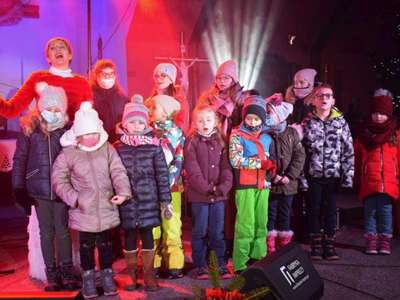 Wokalistka oraz dzieci śpiewając na scenie