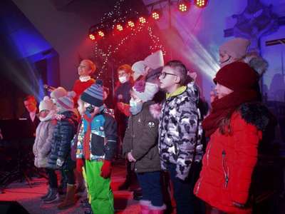 Wokalistka oraz dzieci śpiewając na scenie