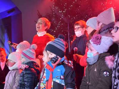 Wokalistka oraz dzieci śpiewając na scenie