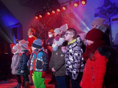 Wokalistka oraz dzieci śpiewając na scenie