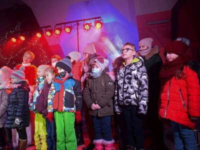 Wokalistka oraz dzieci śpiewając na scenie