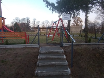 Wejście na plac zabaw, na pierwszym planie furtka