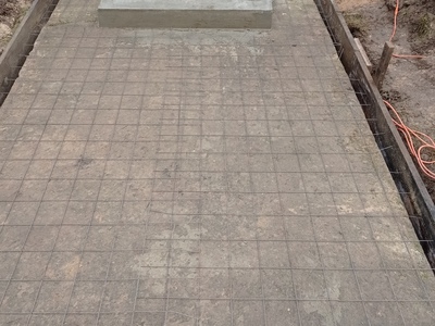 Widok na przygotowane miejsca do wylania betonu pod chodnik prowadzący do kapliczki