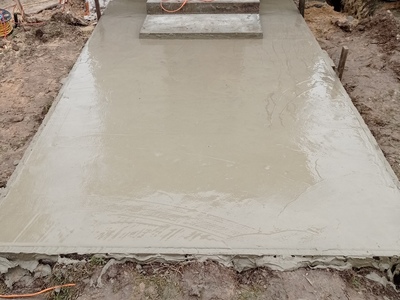 Świeżo wylany chodnik betonowy przy wejściu do kapliczki