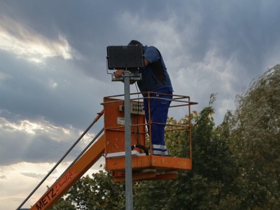 Elektryk na podnośniku naprawiający oświetlenie uliczne