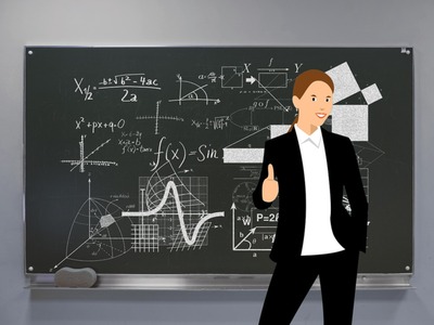 Nauczycielka stojąca przez tablicą trzymająca kciuk uniesiony w górę