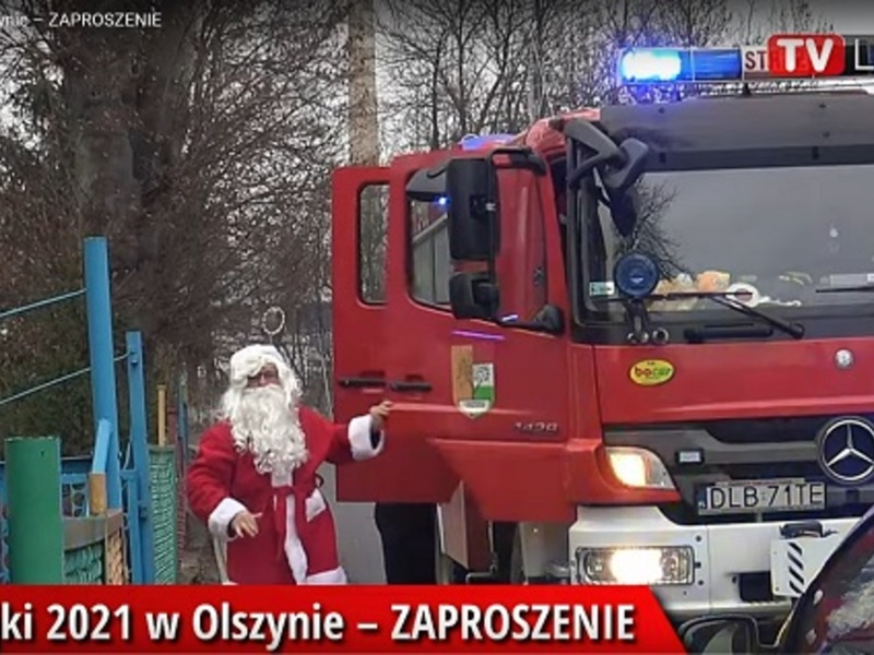 Mikołaj wysiada z wozu strażackiego i serdecznie się wita z dziećmi.
