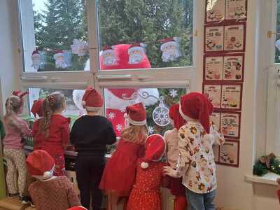 Grupa przedszkolaków patrząca przez okno. Wewnątrz.